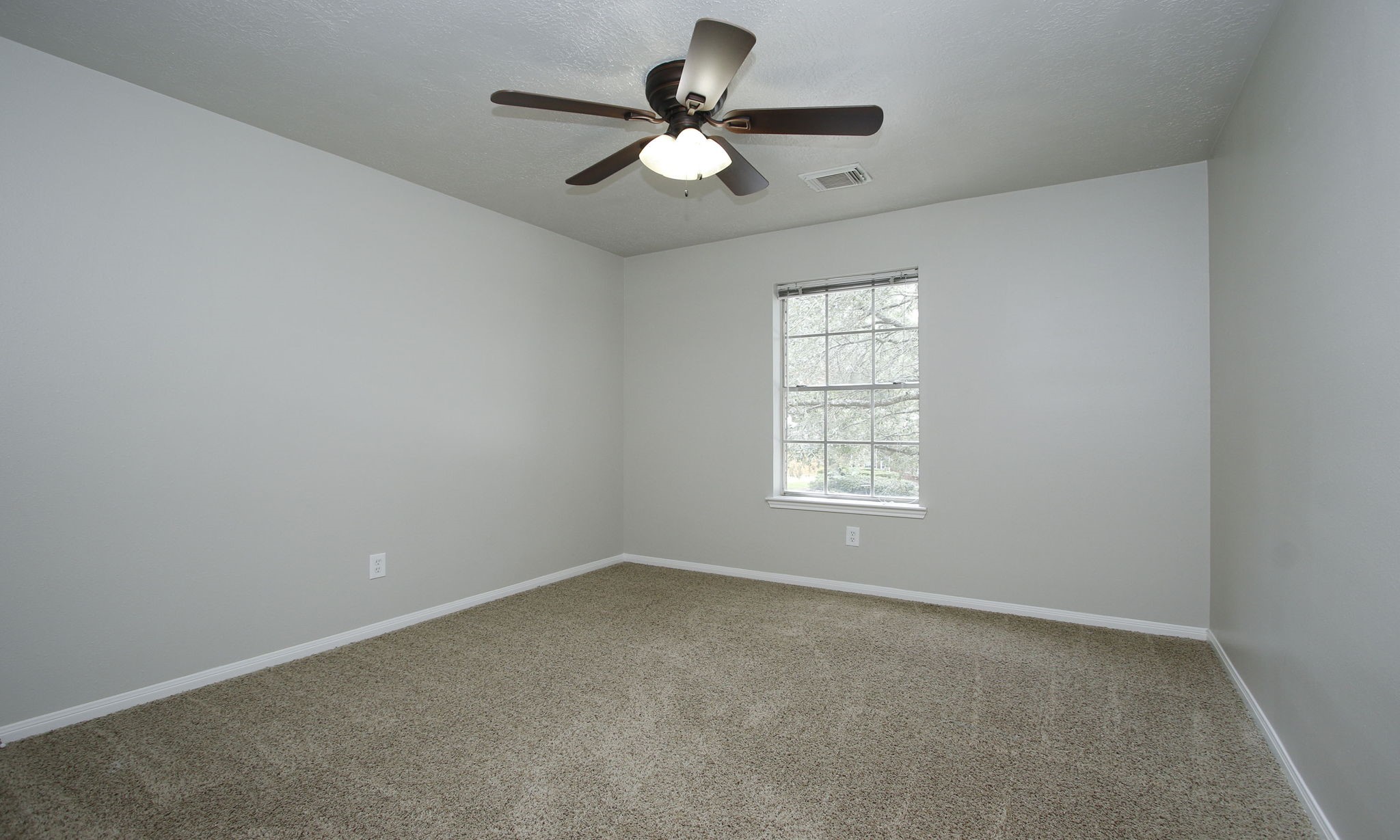 1915 West Welsford Drive Spring, TX 77386 - Photo 39 of 48 an empty room with a window and a fan