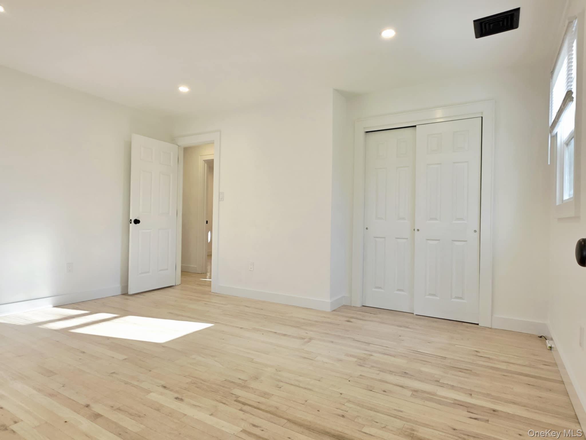 185 Wakeman Road Hampton Bays, NY 11946 - Photo 12 of 14 Unfurnished bedroom featuring light wood finished floors, a closet, and recessed lighting