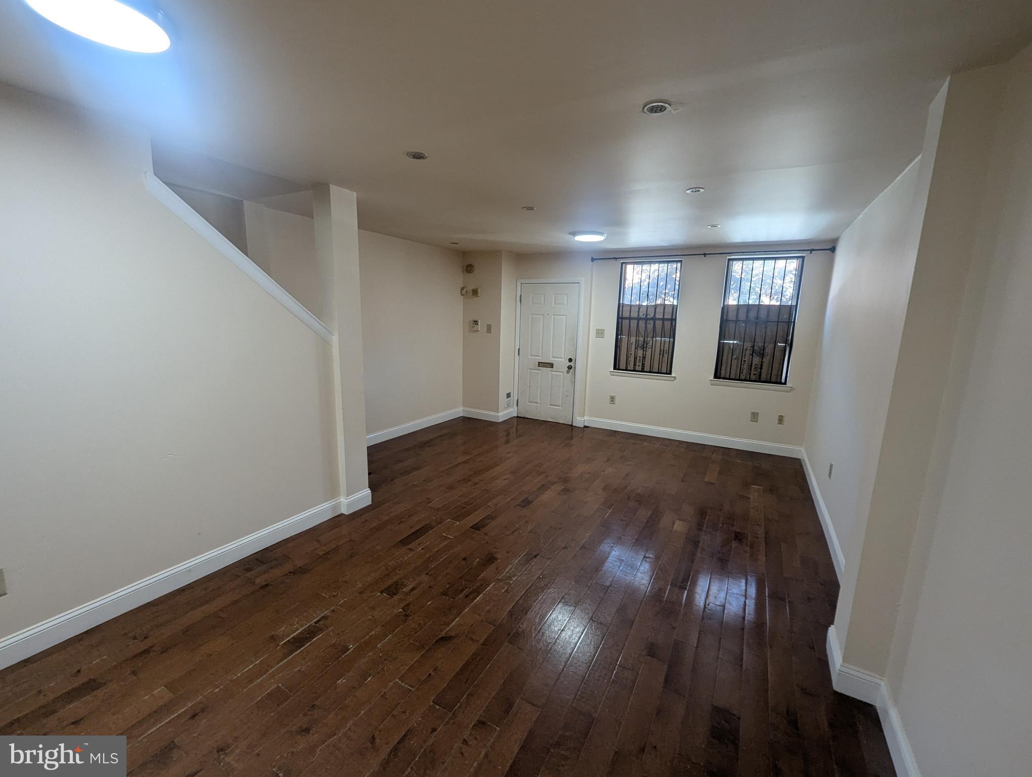 1624 West Diamond Street Philadelphia, PA 19121 - Photo 4 of 38 an empty room with wooden floor and mirror