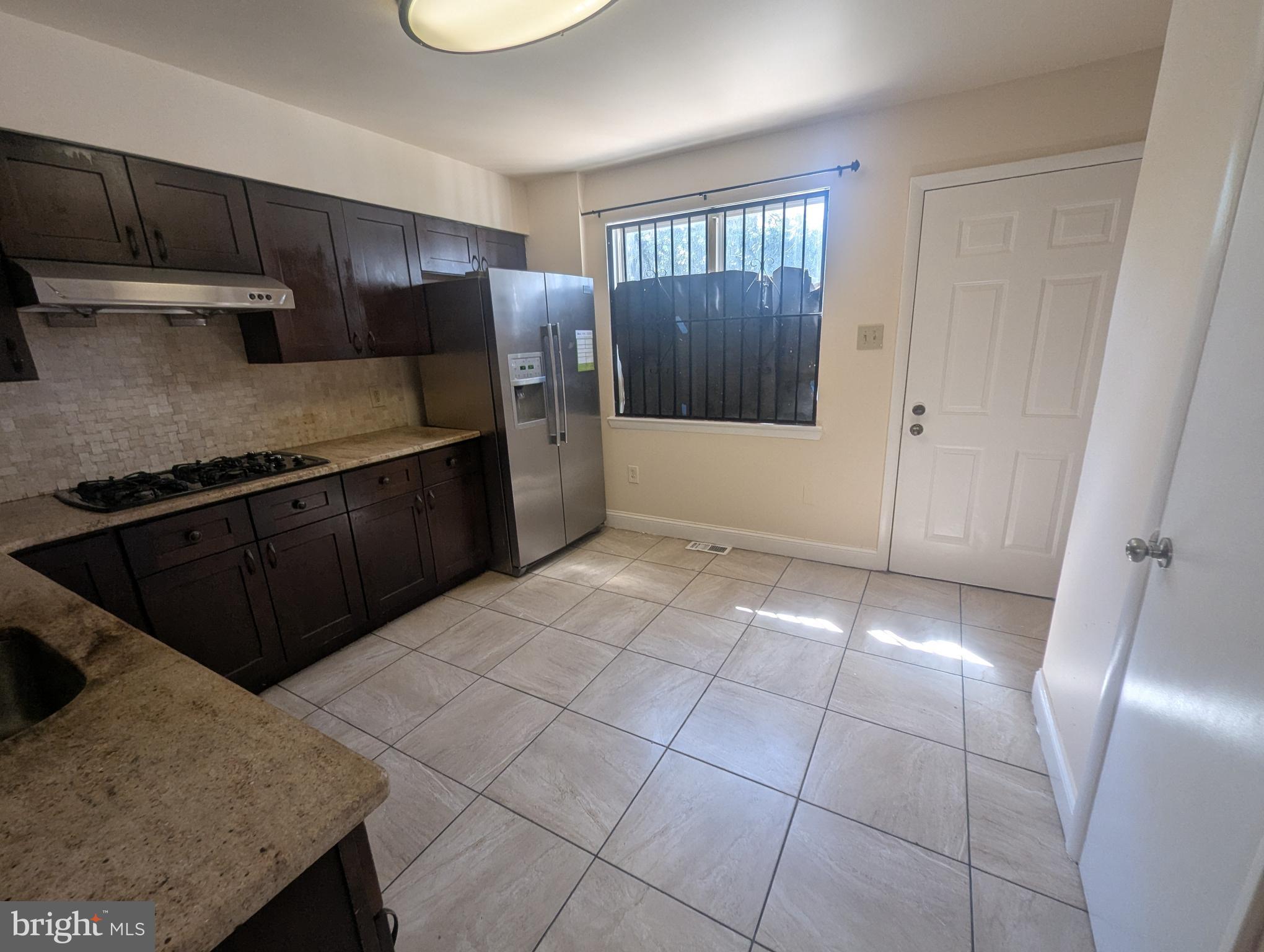 1624 West Diamond Street Philadelphia, PA 19121 - Photo 6 of 38 a kitchen with granite countertop a refrigerator and a stove top oven