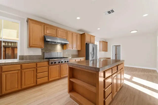 a kitchen with stainless steel appliances granite countertop a stove and a refrigerator