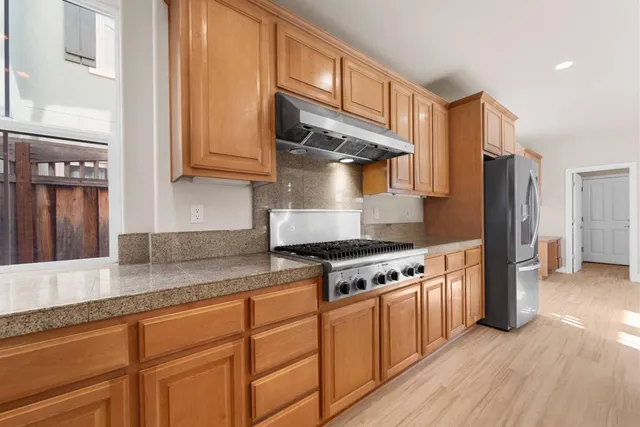 a kitchen with stainless steel appliances granite countertop a stove and a refrigerator