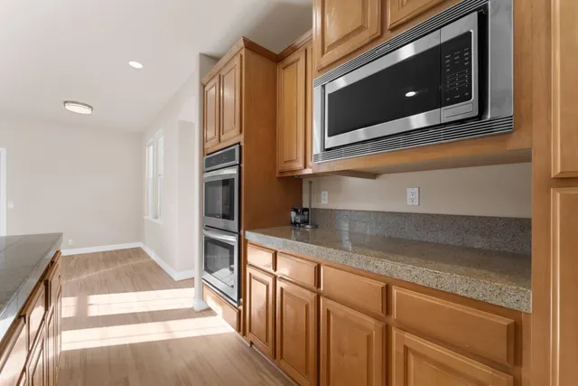 a kitchen with stainless steel appliances granite countertop a refrigerator and a microwave