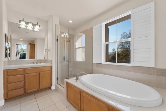a bathroom with a tub a sink and a large mirror