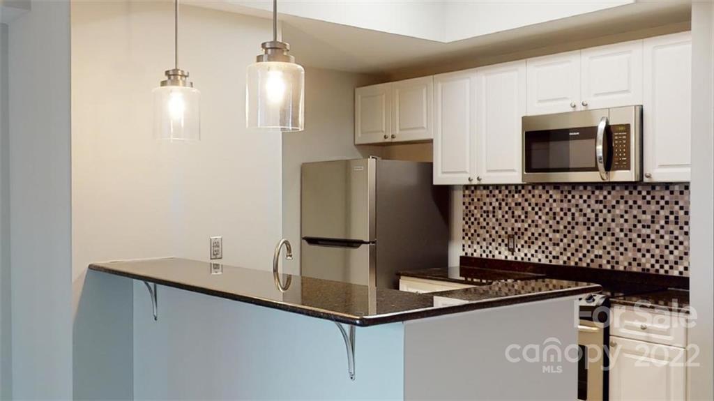 300 West 5th Street, Unit 339 Charlotte, NC 28202 - Photo 16 of 40 a kitchen with a sink a refrigerator and microwave