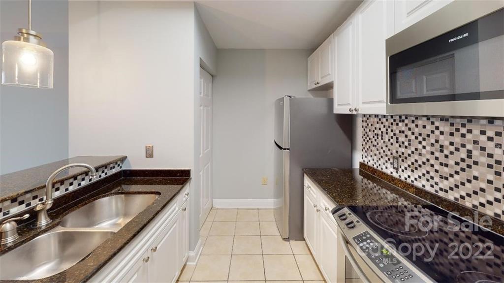300 West 5th Street, Unit 339 Charlotte, NC 28202 - Photo 19 of 40 a kitchen with a sink a stove and cabinets