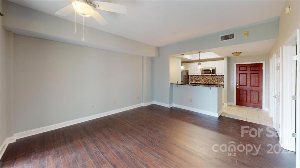 300 West 5th Street, Unit 339 Charlotte, NC 28202 - Photo 20 of 40 an empty room with wooden floor and a kitchen