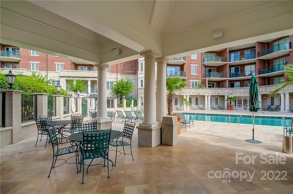 300 West 5th Street, Unit 339 Charlotte, NC 28202 - Photo 40 of 40 a view of a patio with table and chairs and floor to ceiling window wooden fence