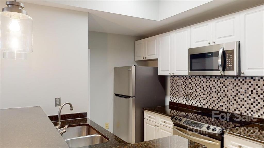 300 West 5th Street, Unit 339 Charlotte, NC 28202 - Photo 10 of 40 a kitchen with granite countertop a refrigerator and a stove top oven