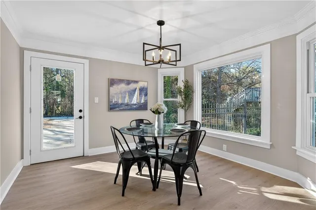 a dining room with furniture a chandelier and wooden floor