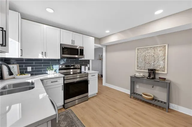 a kitchen with granite countertop a stove top oven and sink