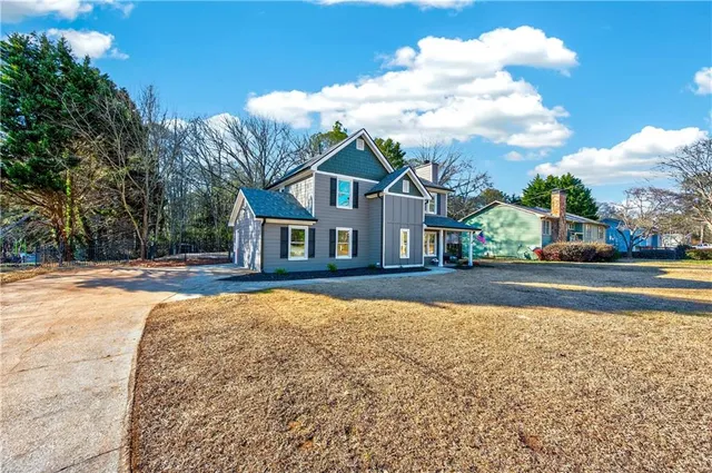 a view of house with yard and car parked