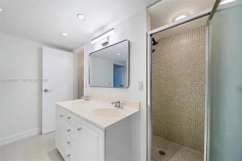 a bathroom with a shower sink vanity and mirror