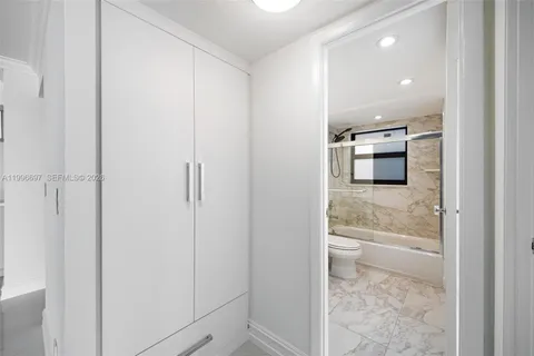 a view of a hallway with wooden floor and cabinet