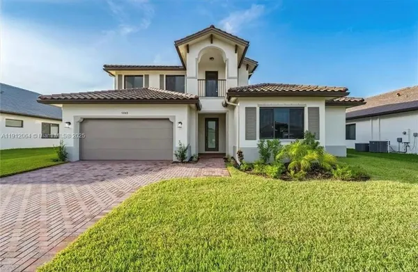 a front view of a house with a yard and garage