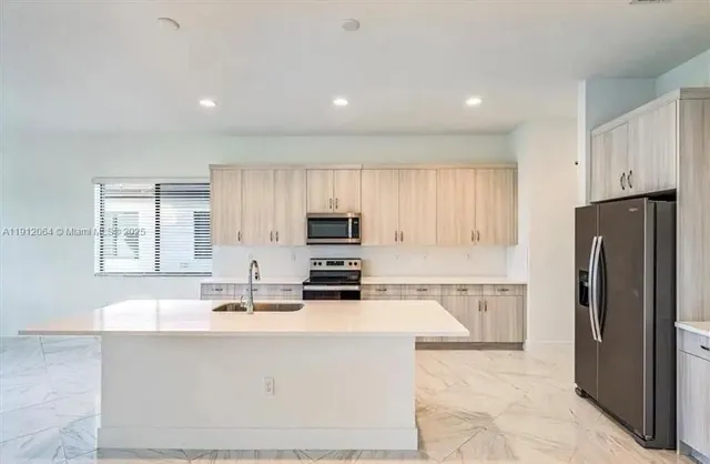 a kitchen with stainless steel appliances a refrigerator sink and microwave