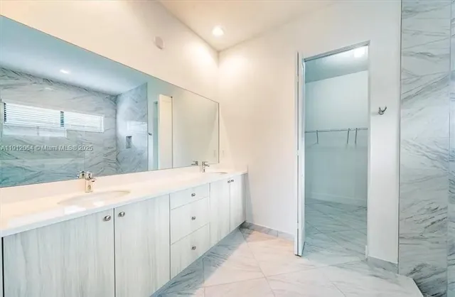 a bathroom with a double vanity sink mirror and shower