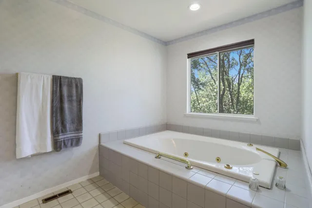 a bathroom with a bathtub and a window
