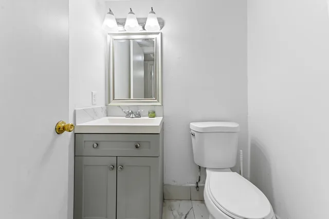 a bathroom with a toilet a sink and mirror