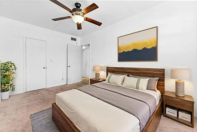 a bedroom with a bed and a painting on the wall