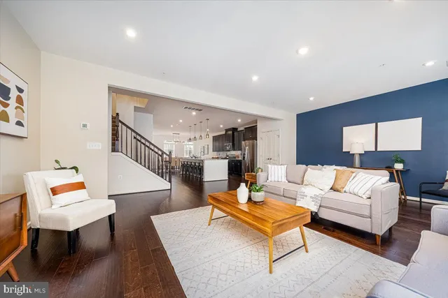 a living room with furniture and a wooden floor