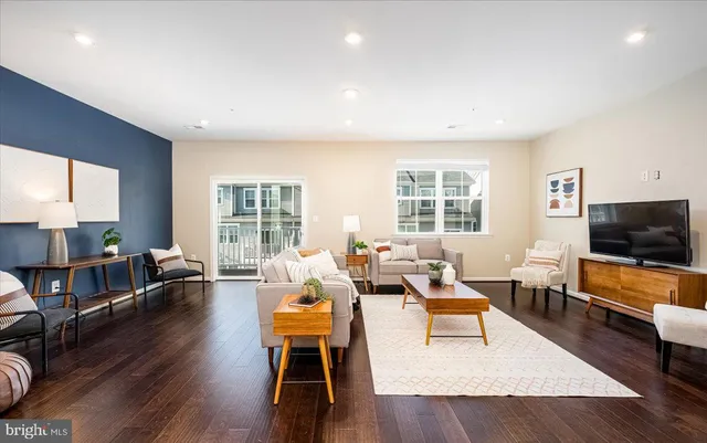 a living room with furniture flat screen tv and wooden floor