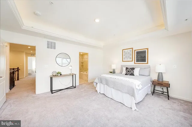 a spacious bedroom with a bed mirror and a table
