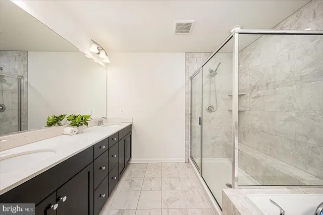 a bathroom with a double vanity sink and shower
