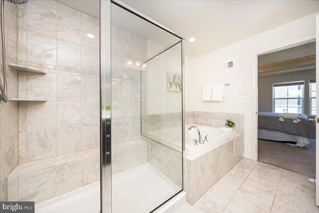 a bathroom with a tub shower and view of bathroom