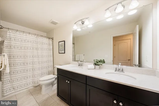 a bathroom with a double vanity sink toilet and shower