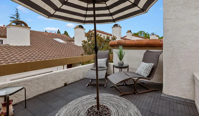 a roof deck with couch and chairs