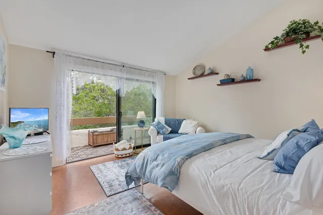 a bedroom with a large bed and a balcony view