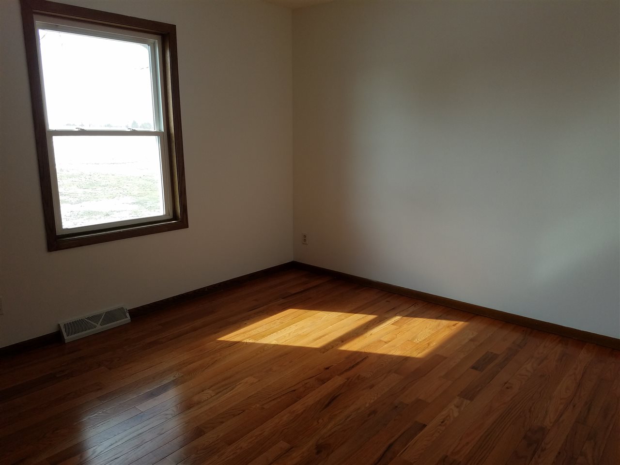 3065 East Stub Road Byron, IL 61010 - Photo 12 of 24 an empty room with wooden floor and windows