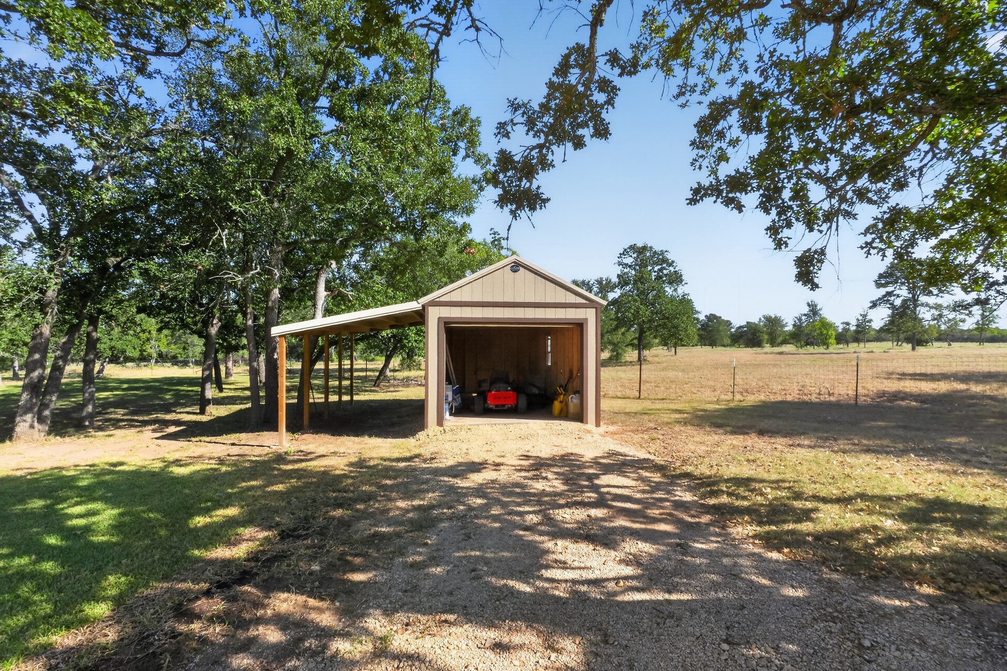 986 High Grove Road Cedar Creek, TX 78612 - Photo 4 of 30 Mature trees shade a versatile outbuilding with an attached carport on this expansive property.