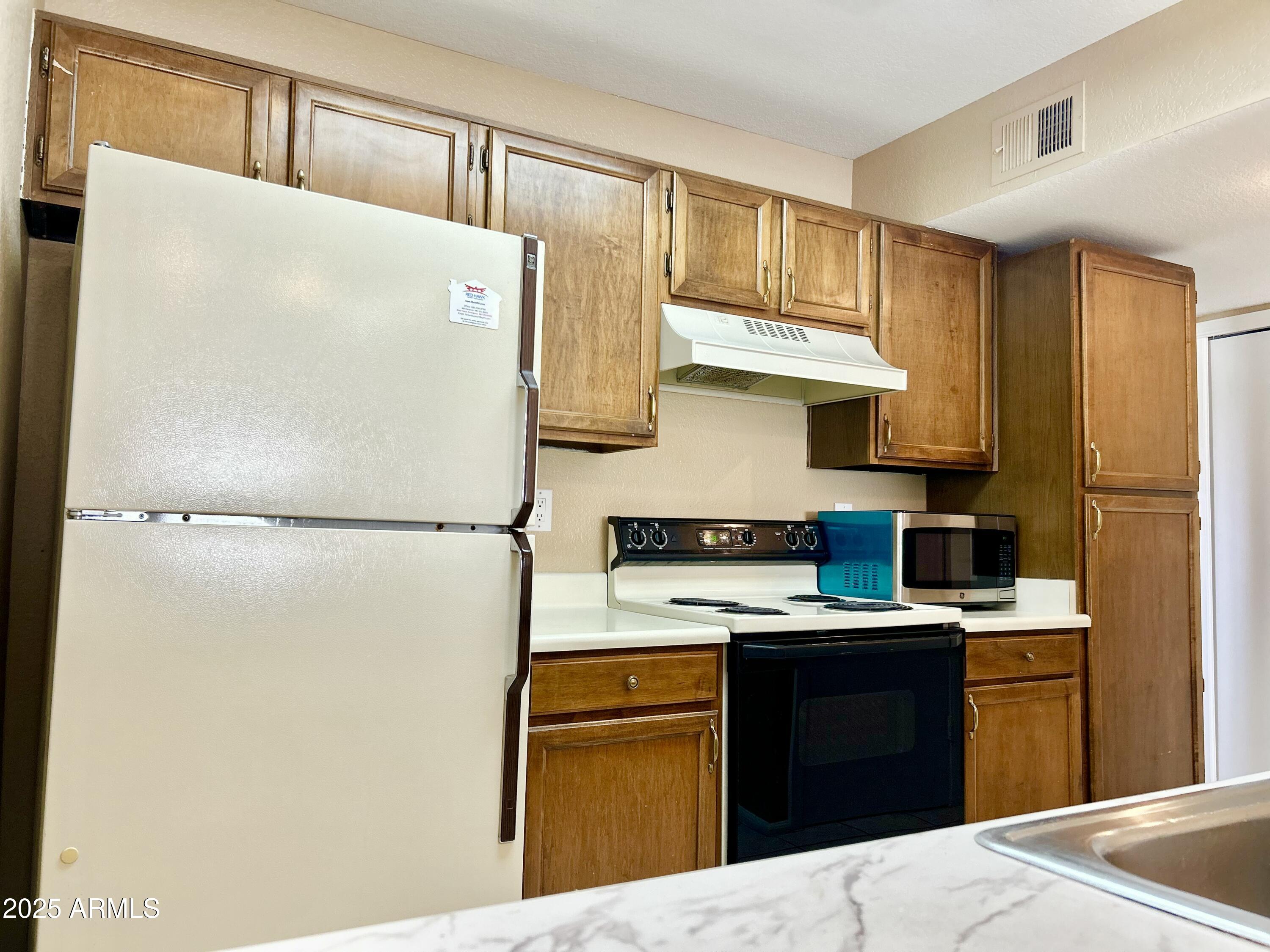 623 West Guadalupe Road, Unit 217 Mesa, AZ 85210 - Photo 5 of 12 a kitchen with a refrigerator and a sink