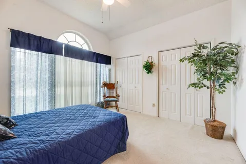 a bedroom with a bed and a potted plant