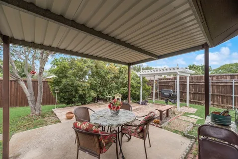 a view of a patio with a table chairs and a backyard