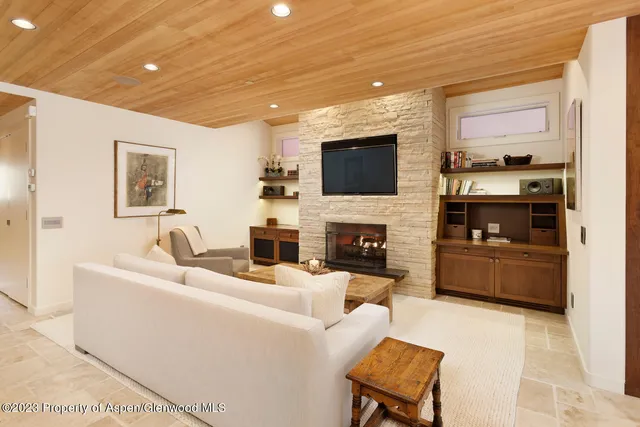a living room with furniture a fireplace and a flat screen tv