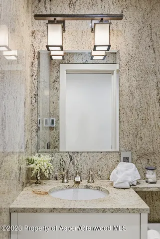 a bathroom with a granite countertop sink and a mirror