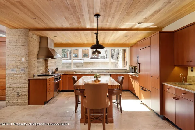 a dining hall with stainless steel appliances granite countertop a stove and a refrigerator