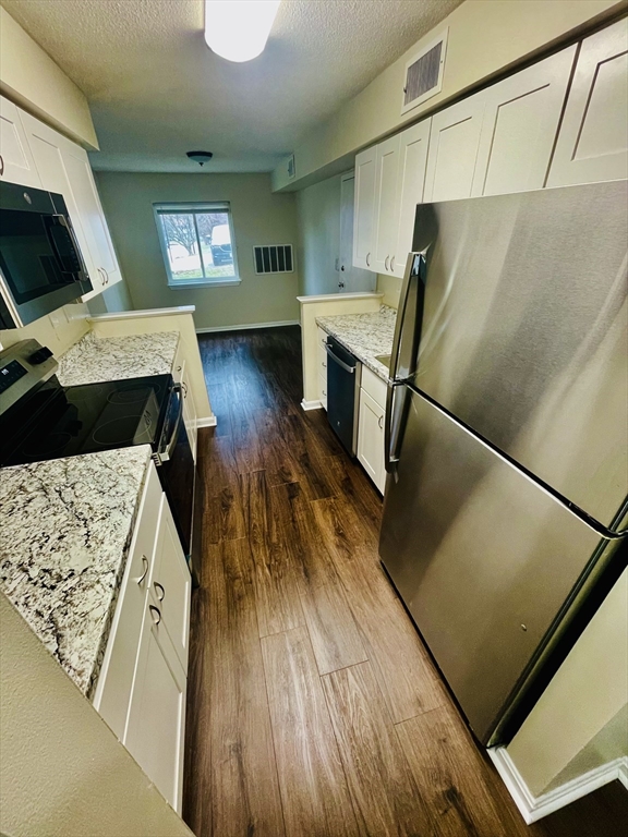 7 Beal's Cove Road, Unit 7A Hingham, MA 02043 - Photo 3 of 8 a kitchen with a wooden floor and a refrigerator