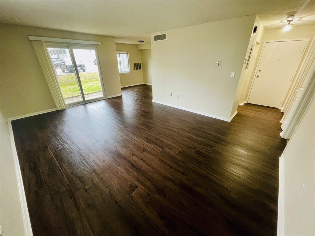 7 Beal's Cove Road, Unit 7A Hingham, MA 02043 - Photo 4 of 8 a view of an empty room with wooden floor and a window