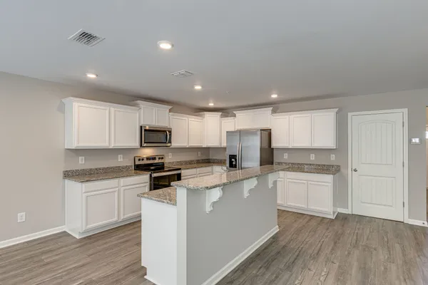 a kitchen with white cabinets stainless steel appliances and sink