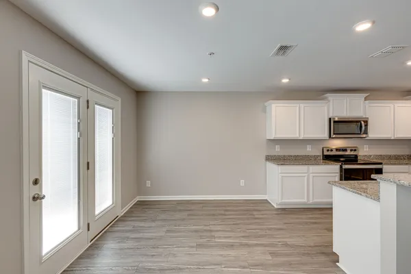 a kitchen with stainless steel appliances granite countertop a stove a sink and a refrigerator with wooden floor
