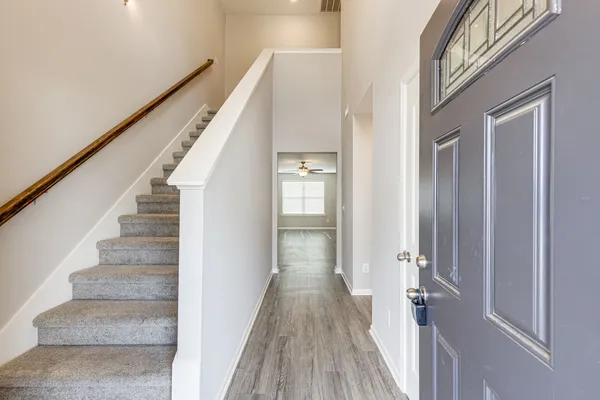 a view of a hallway with wooden floor and staircase
