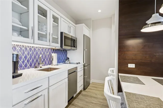 a kitchen that has a sink and a stove with wooden floor