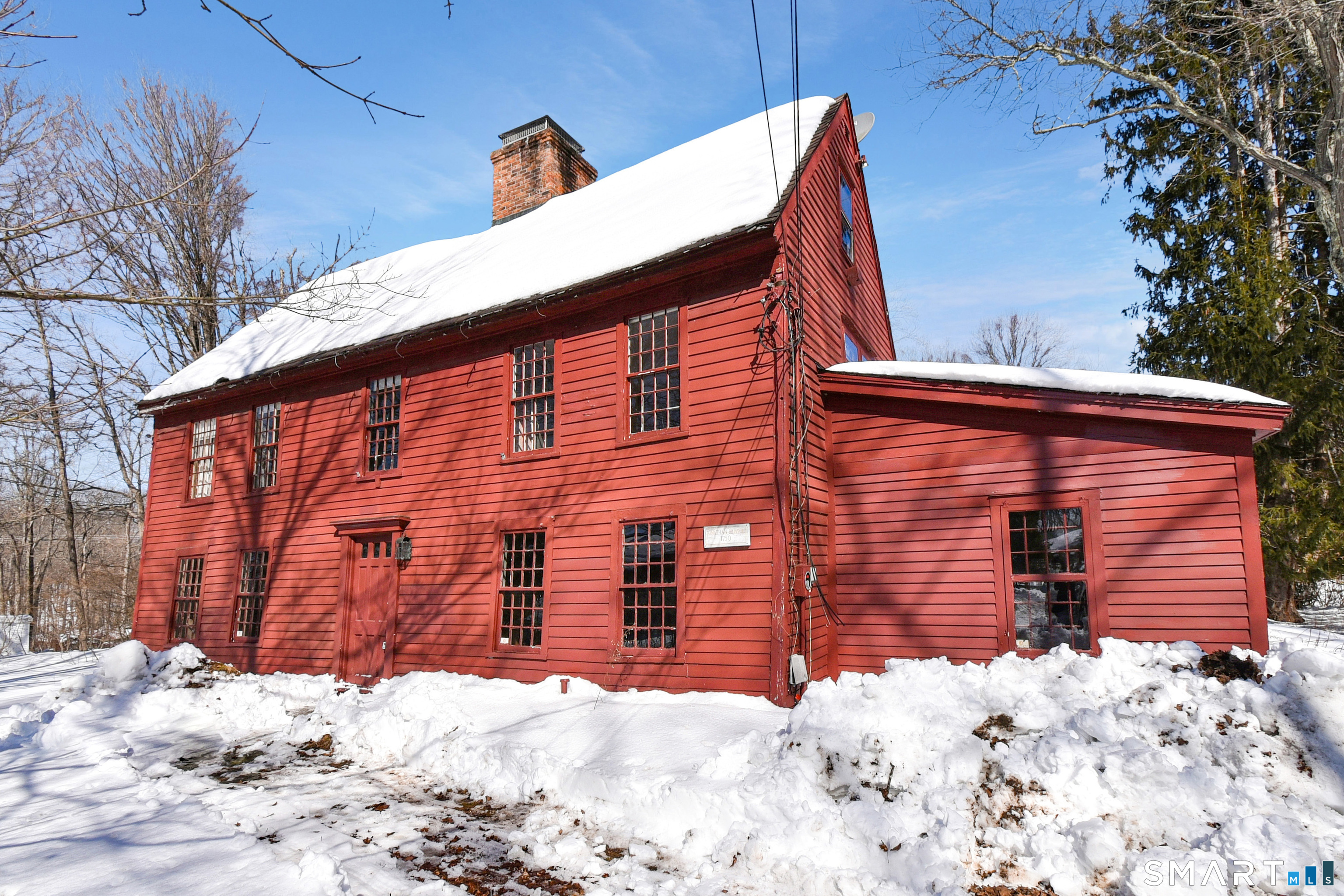 a front view of a house with a yard covered in snow