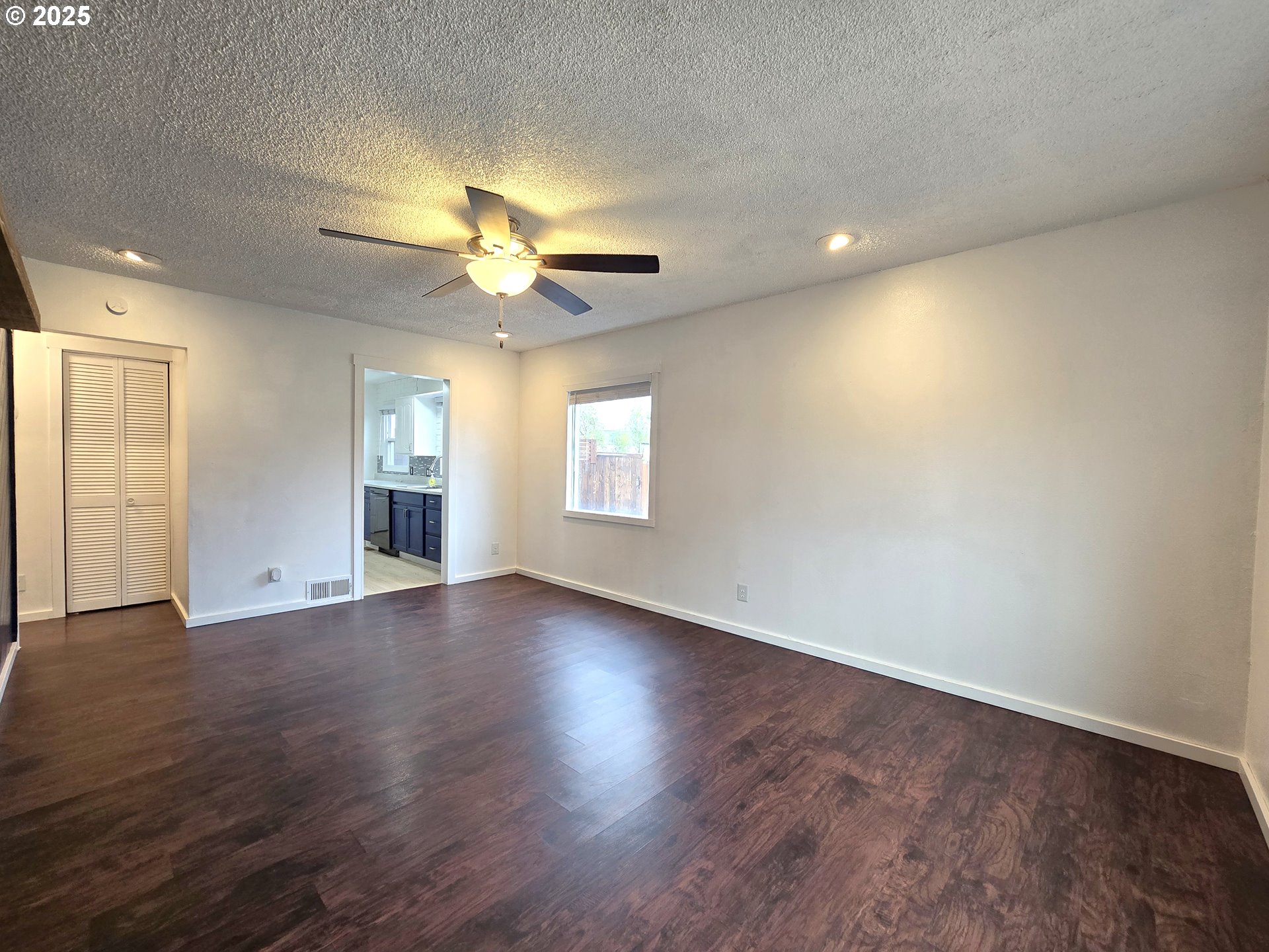 460 East Sunset Drive Hermiston, OR 97838 - Photo 4 of 32 an empty room with wooden floor chandelier fan and windows