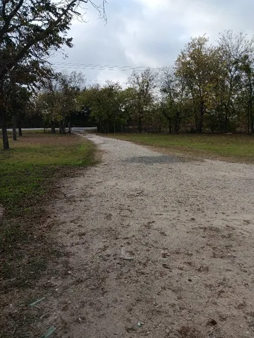 a view of a field with trees in the background