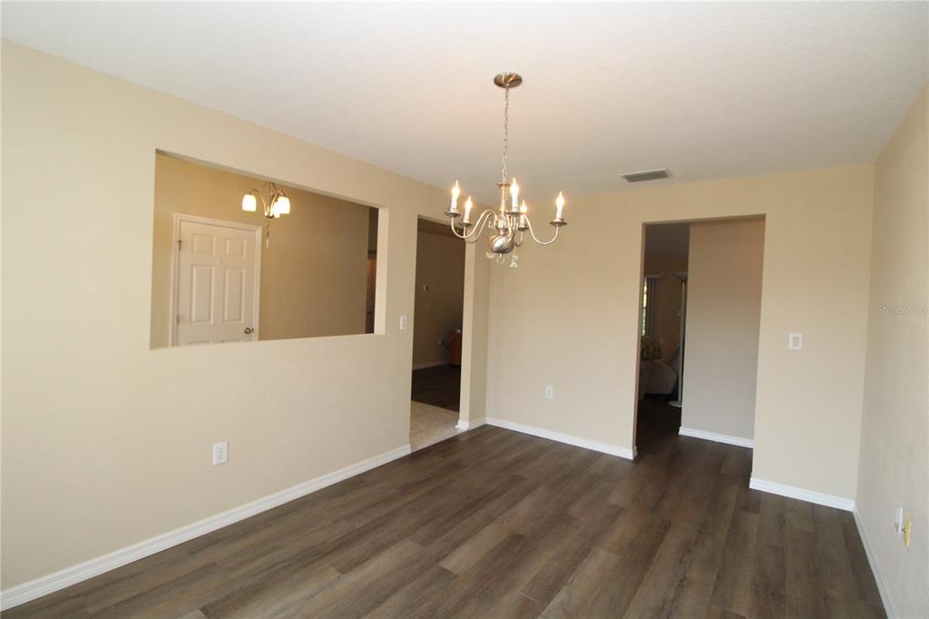 7432 Perennial Road North Port, FL 34291 - Photo 13 of 61 a view of a chandelier in a room with wooden floor